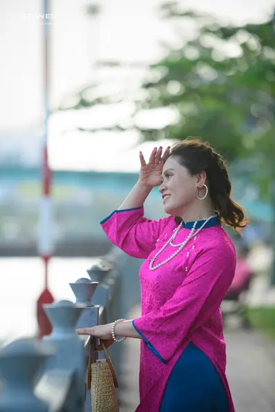 Dancesport competitor: Female dancer: pink patterned long-sleeved top with blue trim, blue skirt, pearl
