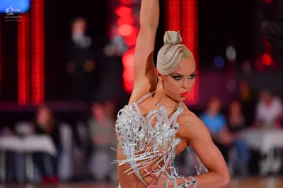 Dancesport competitor: Female dancer: silver Latin dance costume heavily embellished with sequins and c