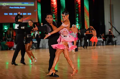 Dancesport competitor: Male dancer (foreground): black long-sleeved shirt and trousers