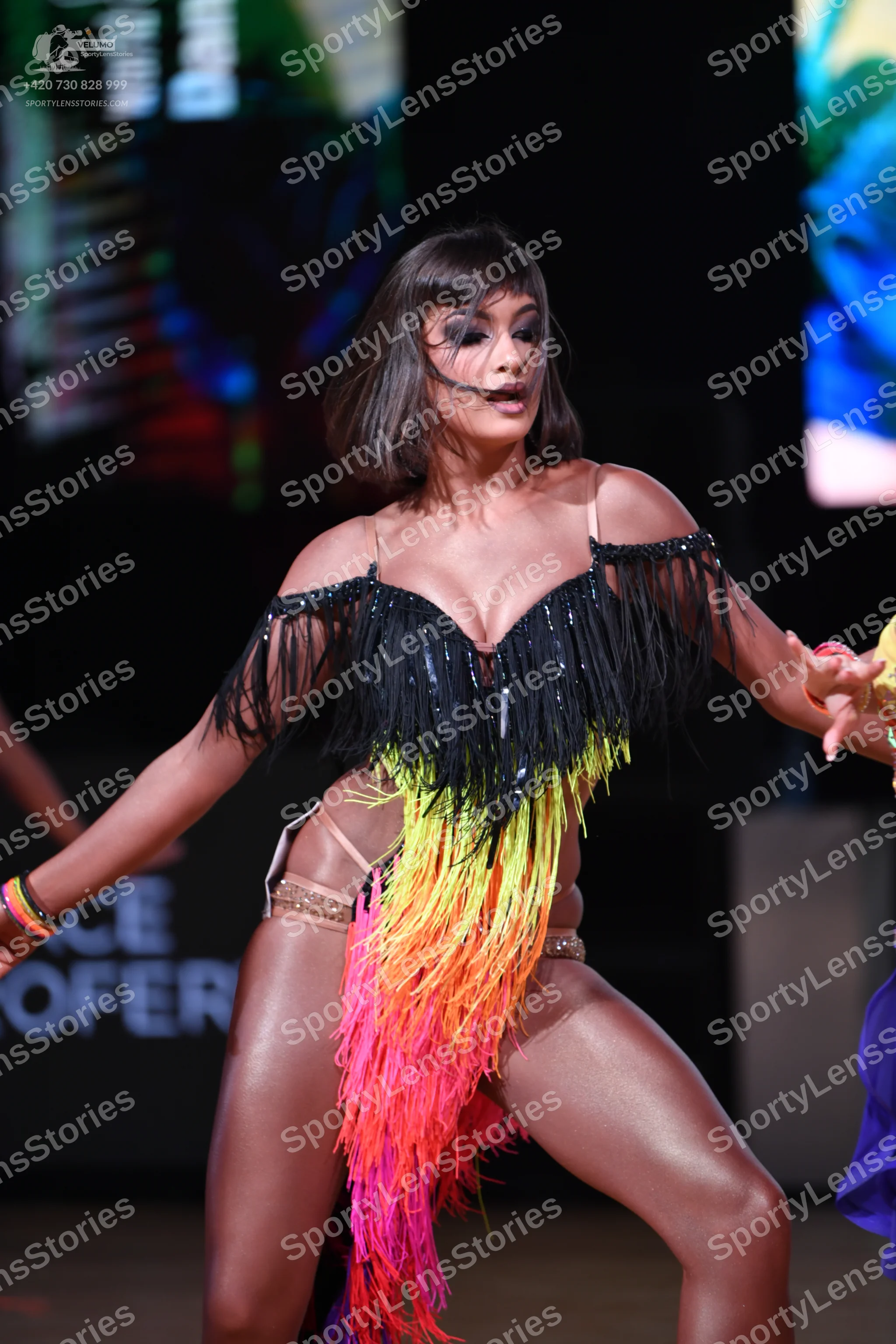 Dancesport competitor: Female dancer: Latin dance dress with a black sequin bodice, black fringe at the