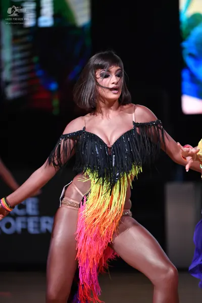 Dancesport competitor: Female dancer: Latin dance dress with a black sequin bodice, black fringe at the