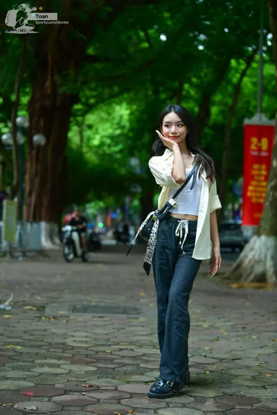 Dancesport competitor: Female dancer: white crop top, cream-colored open shirt, and dark blue flared je