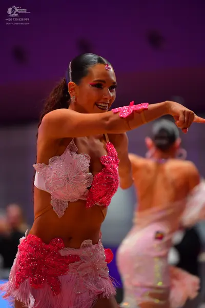Dancesport competitor: Female dancer 1: pink and white two-piece latin costume with sequin floral patte