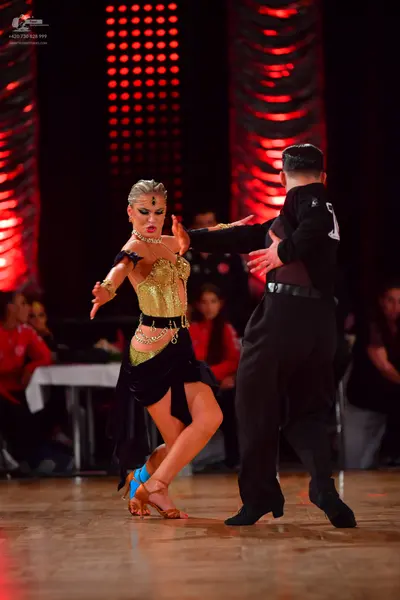 Dancesport competitor: Male dancer: black long-sleeved shirt with a white number 7 on the back and blac