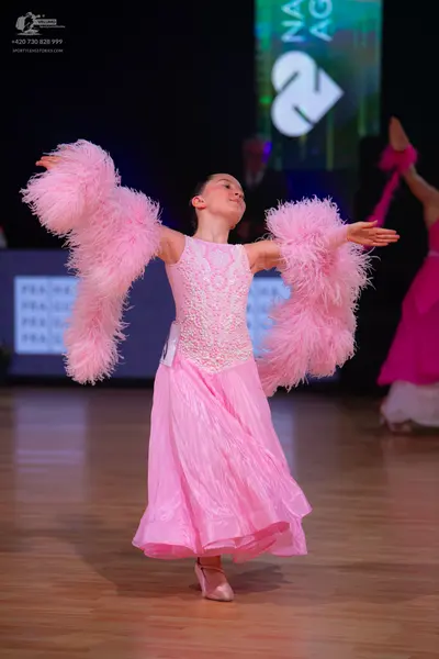 Dancesport competitor: Main dancer: light pink ballgown featuring an embroidered lace bodice, a volumin