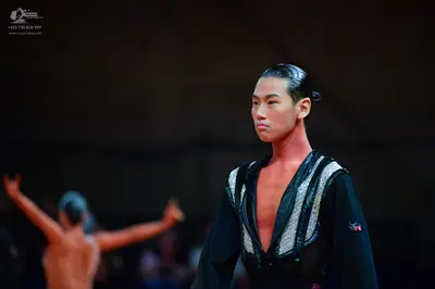 Dancesport competitor: Male dancer: black long-sleeved latin dance top with silver sequined trim along 