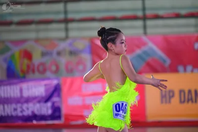 Dancesport competitor #048: ** Bright Yellow, Short, Bodycon Dress
*   **Fabric:** Shiny, likely satin or a 