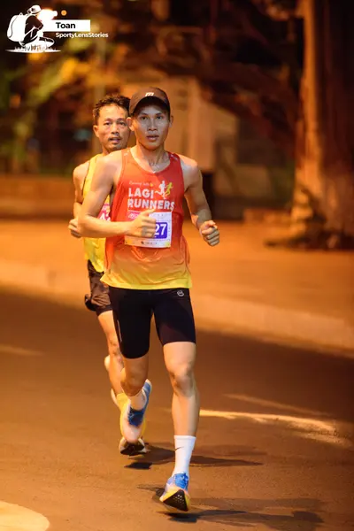Marathon runner #27: Runner 1: red and yellow gradient tank top, black shorts, white socks, blue and 