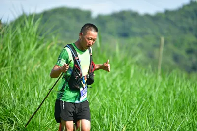 Marathon runner: Runner 1: green and yellow patterned jersey, black shorts, black hydration vest,