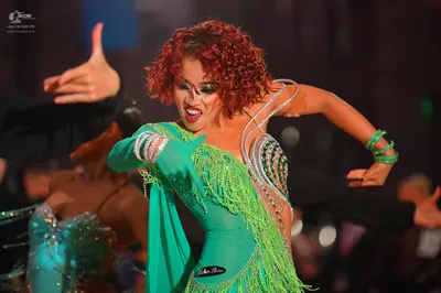 Dancesport competitor: Female dancer: green latin dress with long fringe and sequin embellishments
