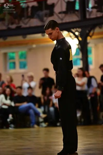 Dancesport competitor: Male dancer: black long-sleeved shirt and black trousers