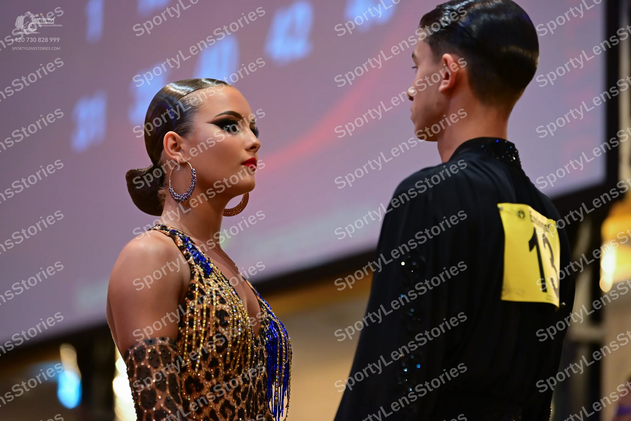 Dancesport competitor #13: Female dancer: leopard print Latin dress with blue and gold sequins and blue bea