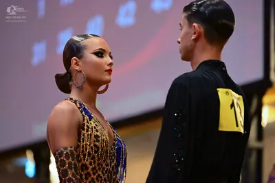 Dancesport competitor #13: Female dancer: leopard print Latin dress with blue and gold sequins and blue bea
