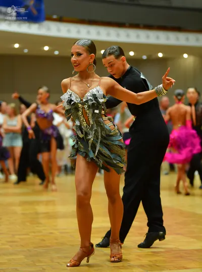 Dancesport competitor: Main female dancer: silver and black sequined Latin dress with an asymmetrical h