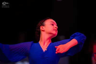 Dancesport competitor: Female dancer: blue long-sleeved dress with a V-neckline and ruching at the bust