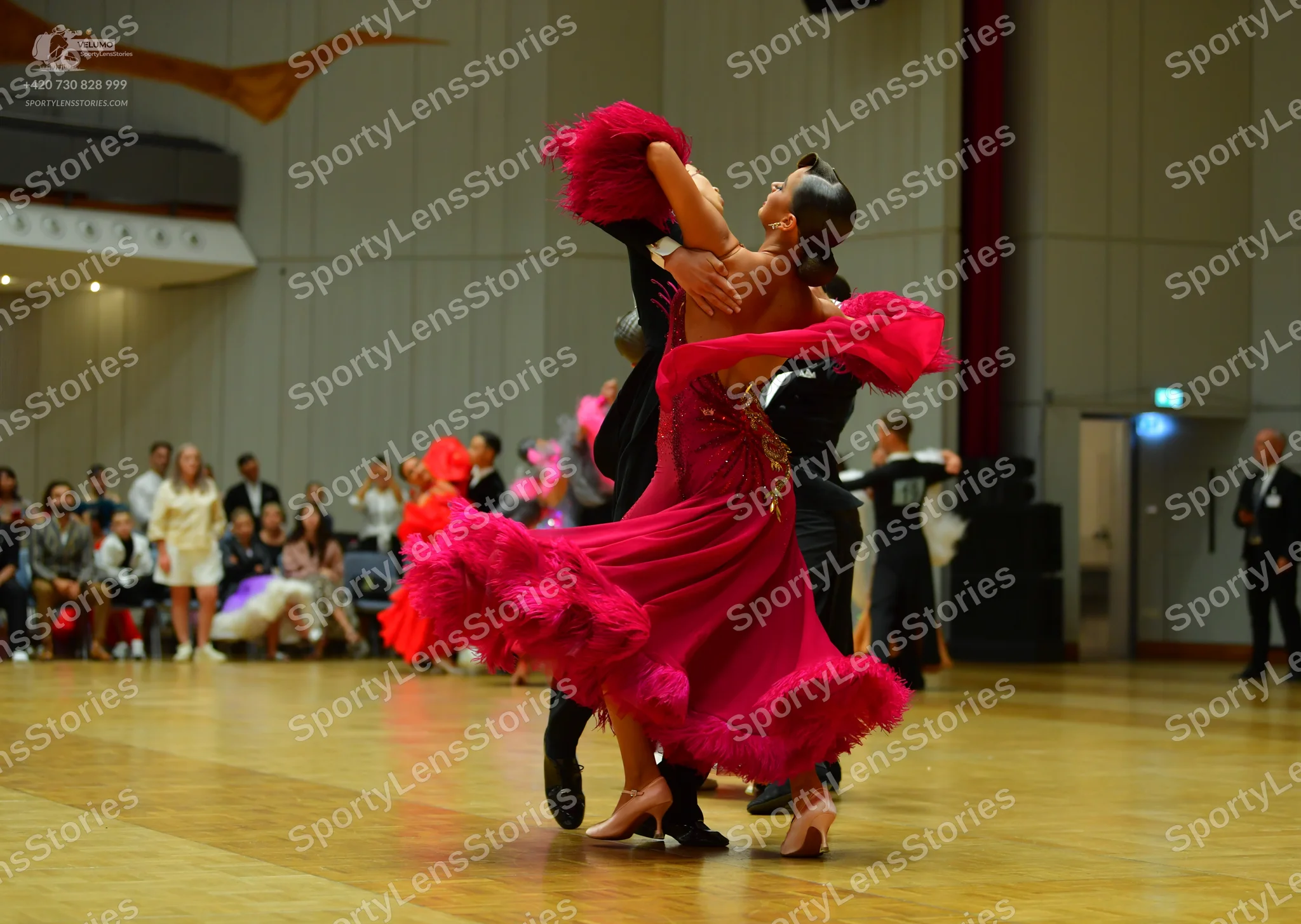 Dancesport competitor: Female dancer: bright pink/magenta Latin dance dress with voluminous flowing fri