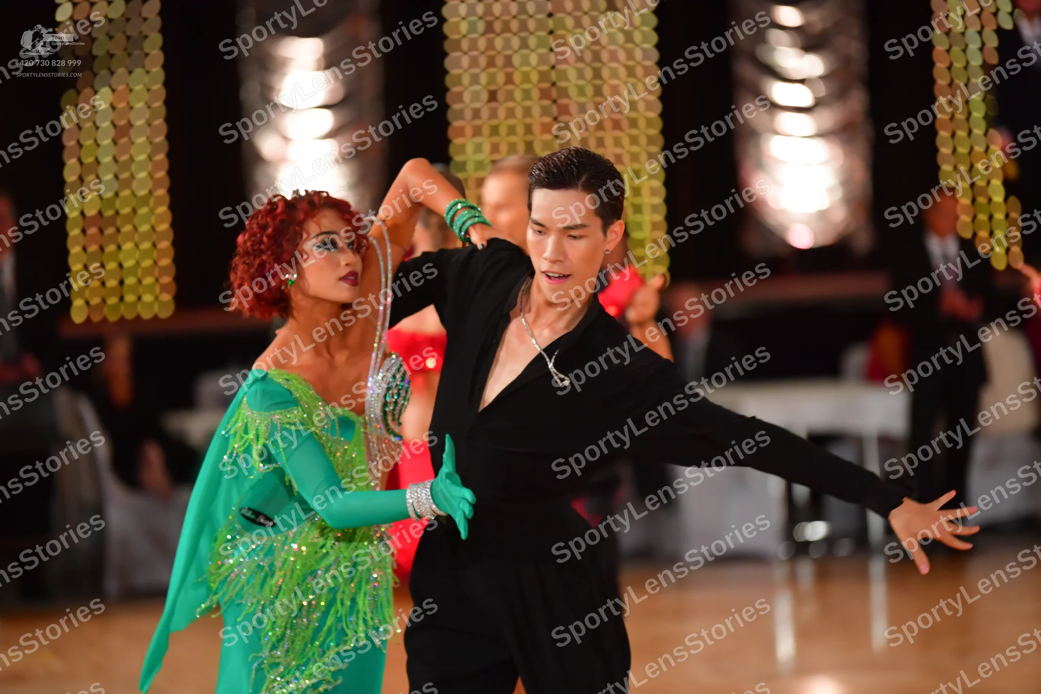 Dancesport competitor: Female dancer: bright green Latin dress with long sleeves, embellished with silv