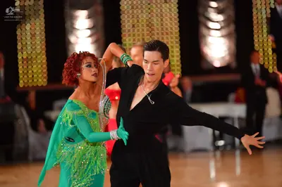 Dancesport competitor: Female dancer: bright green Latin dress with long sleeves, embellished with silv