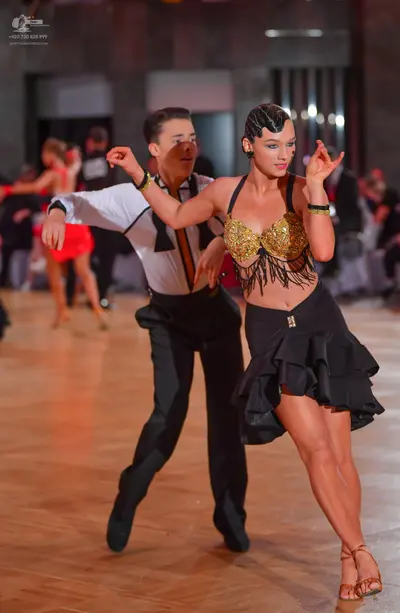 Dancesport competitor: Male dancer: white long-sleeved shirt with black bowtie and black trim, and blac
