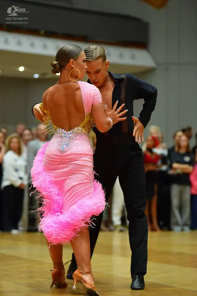 Dancesport competitor: Female dancer: pink latin dress with sequins, backless with gold sequin trim, fe