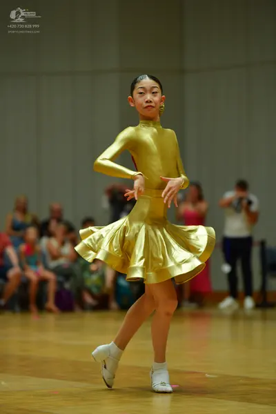 Dancesport competitor: Female dancer: gold metallic long-sleeved dress with a flared skirt