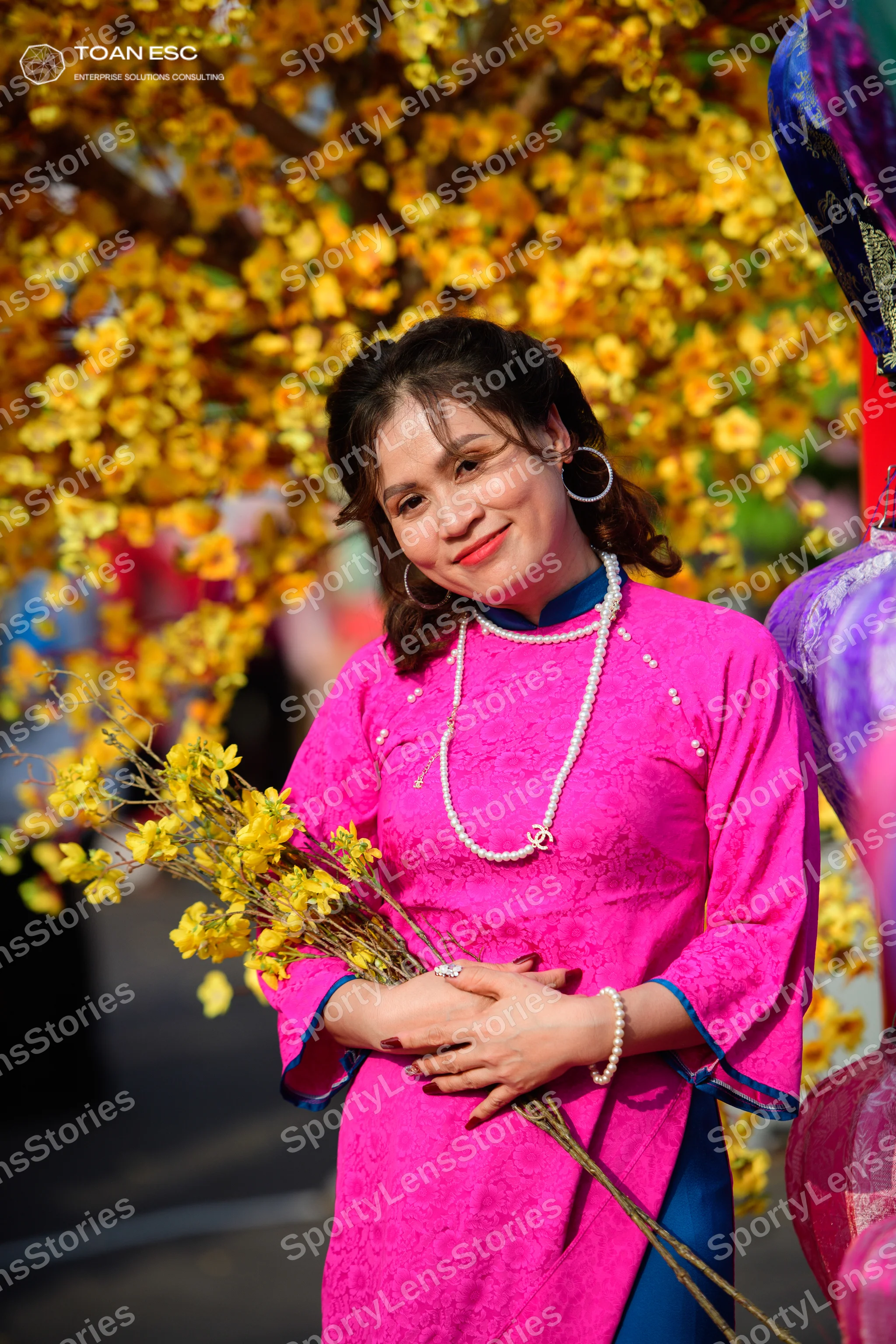 Dancesport competitor: Female dancer: pink lace Ao Dai with blue trim, pearl necklace, pearl bracelet, 