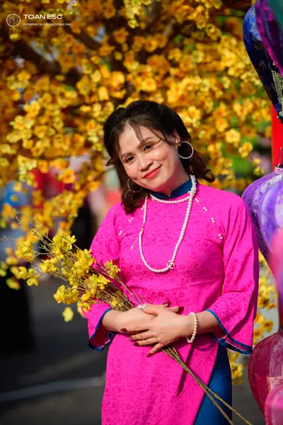 Dancesport competitor: Female dancer: pink lace Ao Dai with blue trim, pearl necklace, pearl bracelet, 