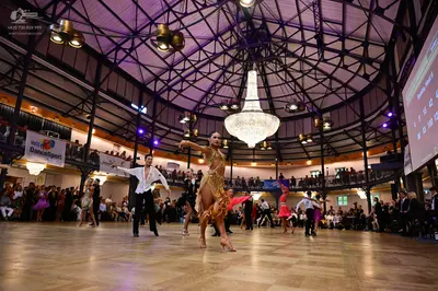 Dancesport competitor: Central female dancer: gold sequined latin dress with fringe and embellishments