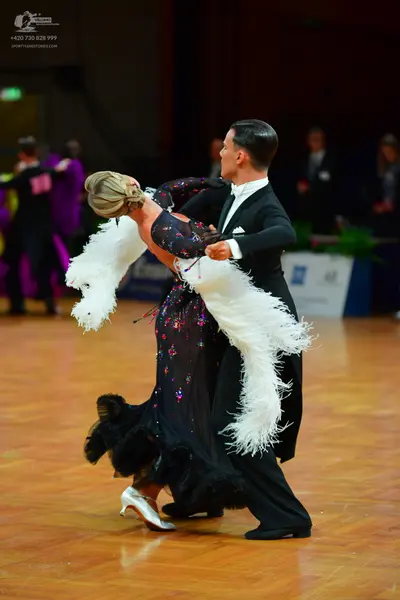 Dancesport competitor: Male dancer: black suit with a white shirt and a dark tie