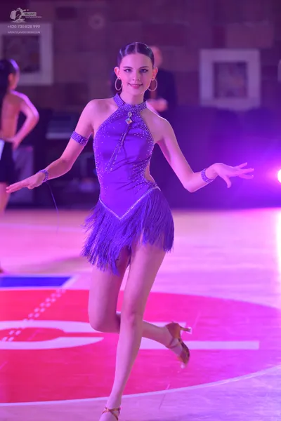 Dancesport competitor: Female dancer: purple latin dress with sequin bodice and fringe skirt, wearing p
