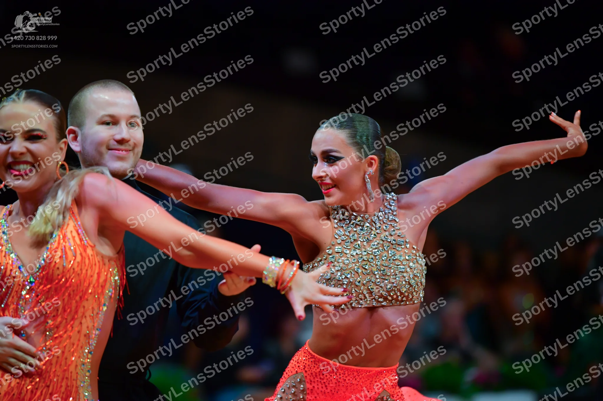 Dancesport competitor: Female dancer on the left: orange/red sequined Latin dance top