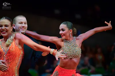 Dancesport competitor: Female dancer on the left: orange/red sequined Latin dance top
