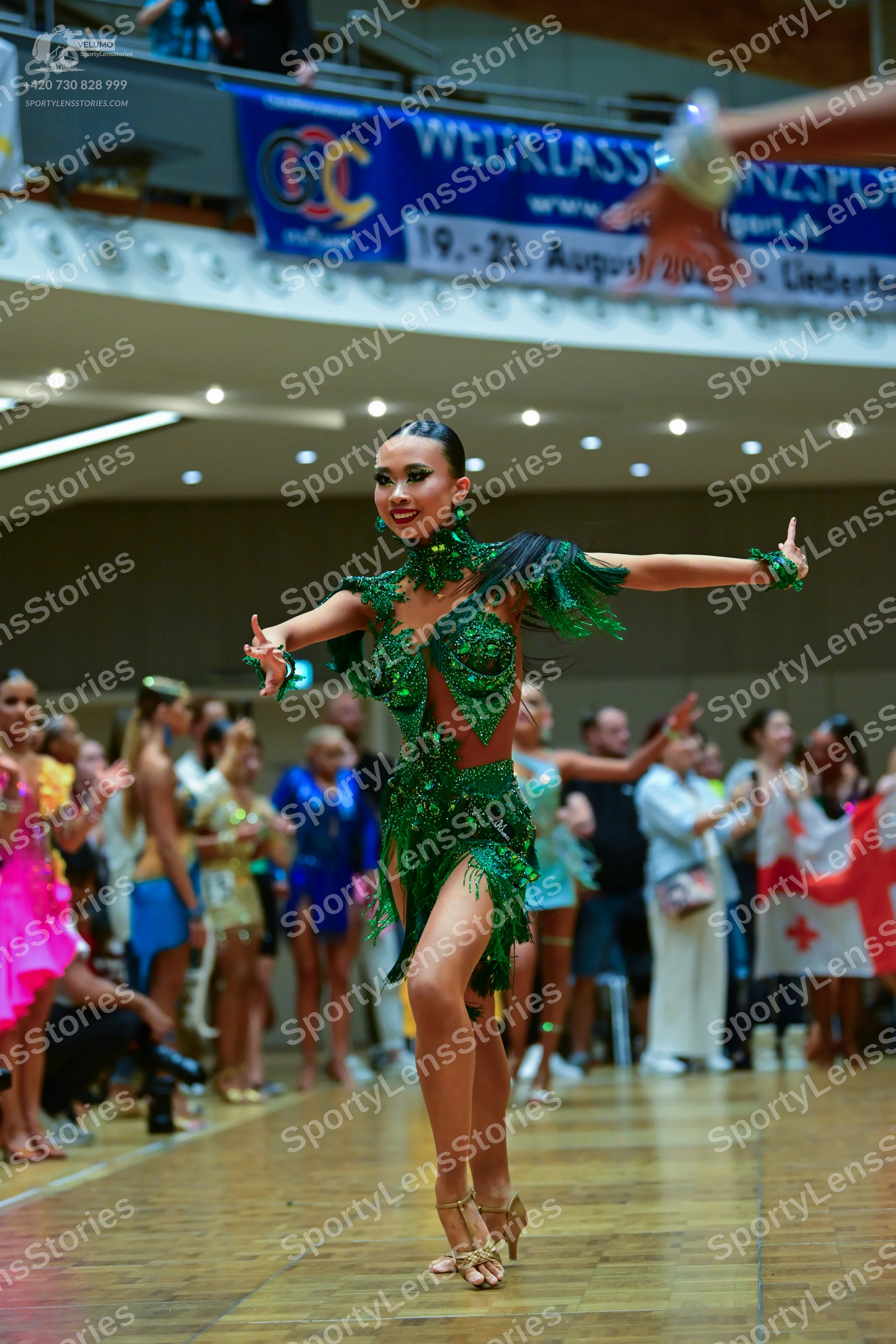 Dancesport competitor: Main dancer: emerald green Latin dance dress heavily embellished with sequins an