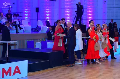 Dancesport competitor: Female dancers: red latin dresses and a white latin dress
