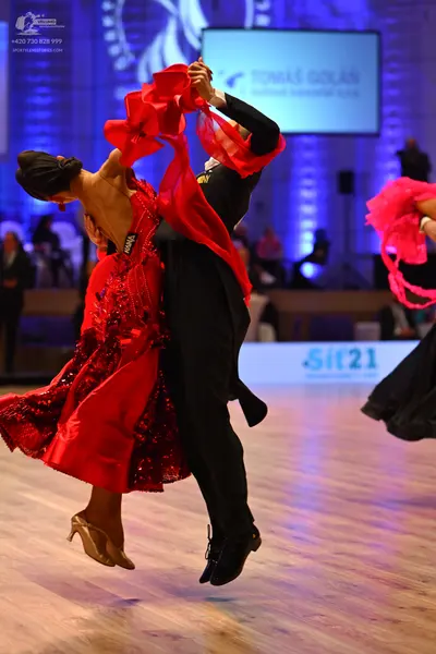 Dancesport competitor: Female dancer: red latin dress with satin-like fabric, red sequins on the skirt,