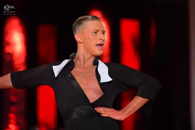 Dancesport competitor: Dancer: black mid-length sleeve top with a deep V-neckline and white collar deta