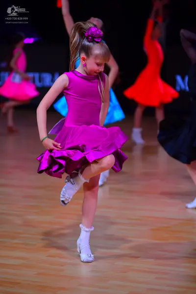 Dancesport competitor: Main dancer: pink satin sleeveless dress with a voluminous ruffled skirt, a purp