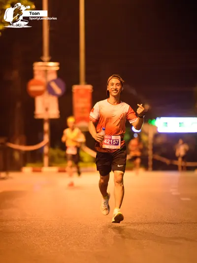 Marathon runner #42157: Runner 1: red/orange jersey, black shorts, white socks, white shoes, dark headba