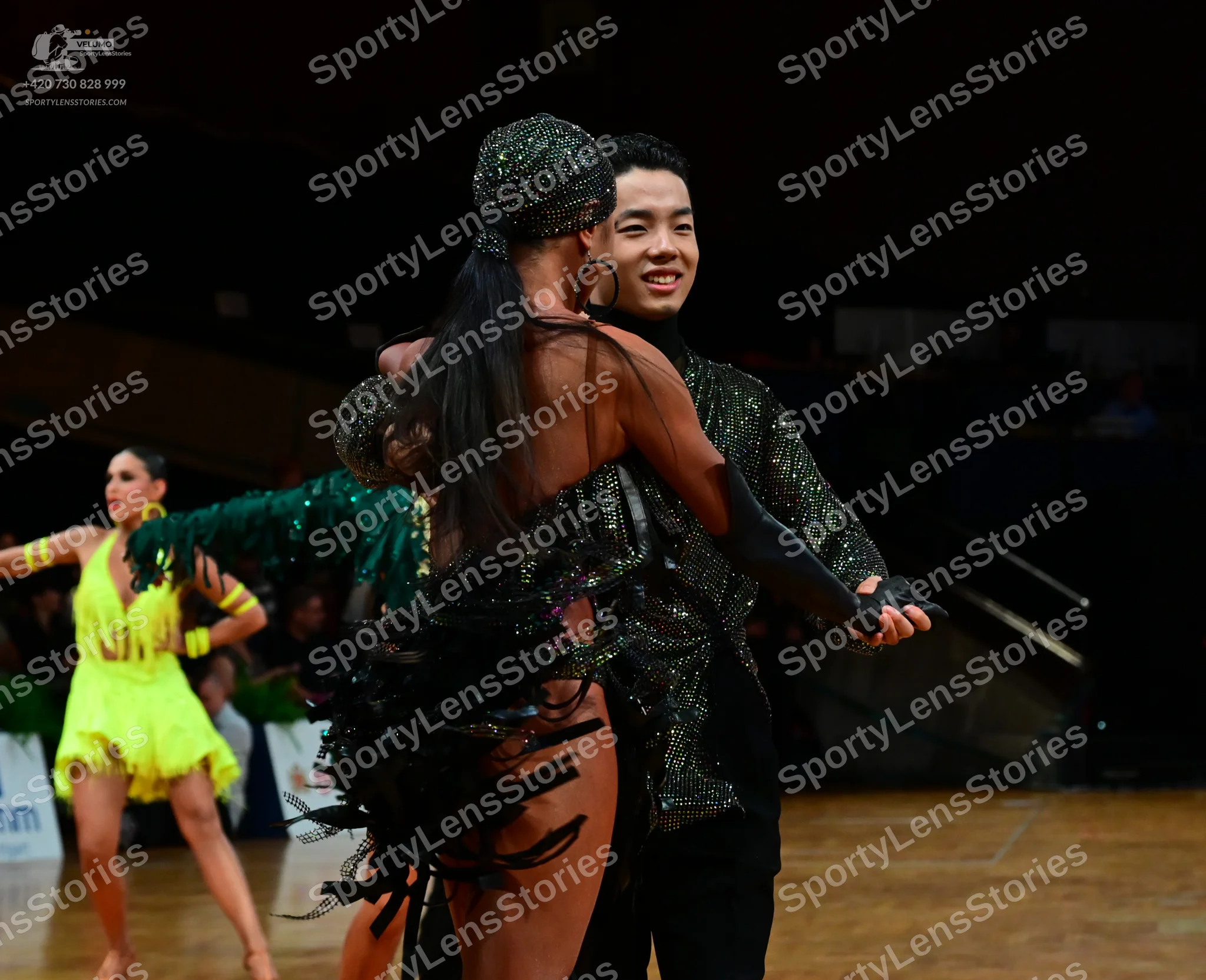 Dancesport competitor: Female dancer (left): yellow Latin dance costume with matching yellow wristbands
