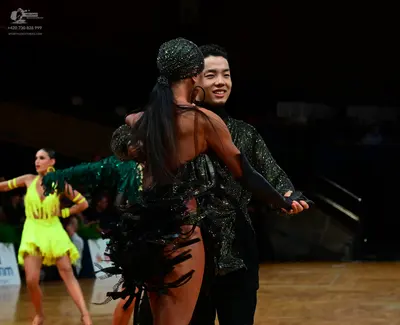 Dancesport competitor: Female dancer (left): yellow Latin dance costume with matching yellow wristbands