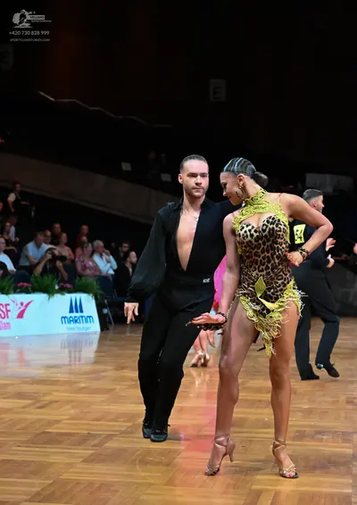 Dancesport competitor: Male dancer: black long-sleeved shirt with a deep V-neck and black trousers