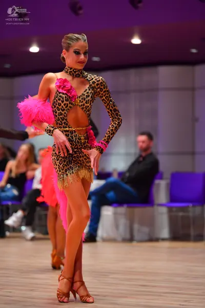 Dancesport competitor: Female dancer 1: leopard print latin dress with long sleeves, midriff cutout, go