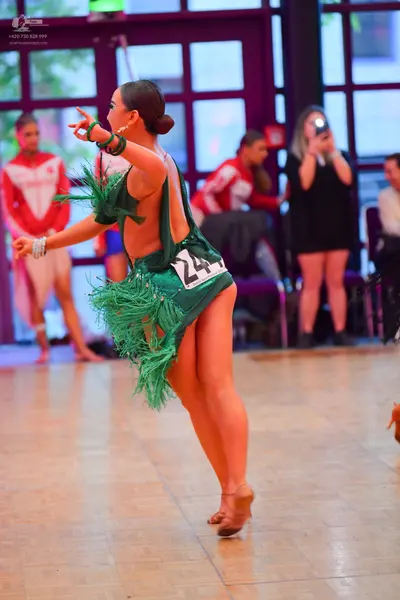 Dancesport competitor #24: Female dancer in foreground: green Latin dress with long green fringe