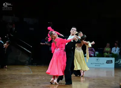 Dancesport competitor: Main female dancer: pink latin dress with a flowy skirt and sequined bodice