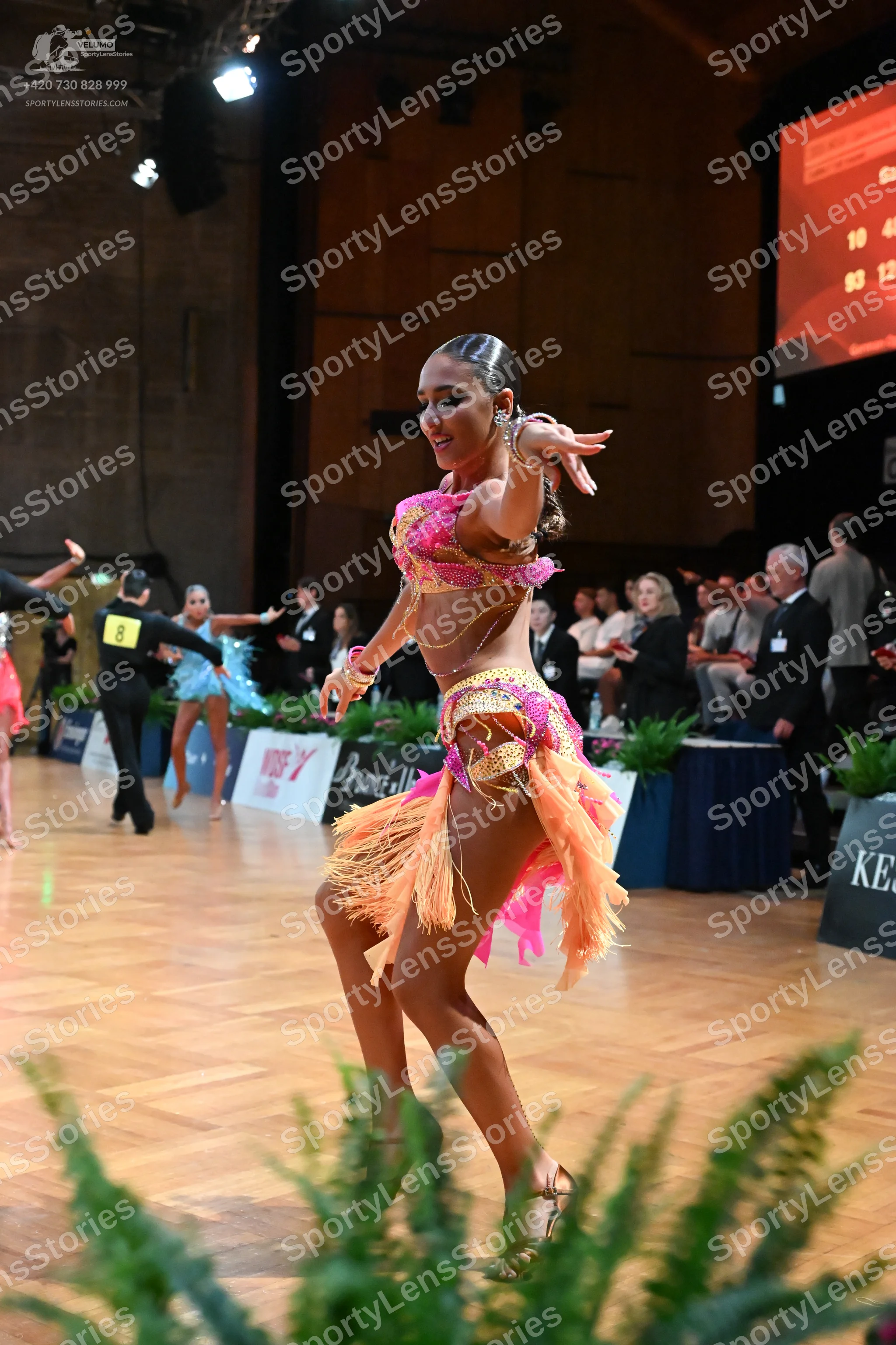 Dancesport competitor: Female dancer: pink and peach latin dress with sequins, lace, and peach fringe