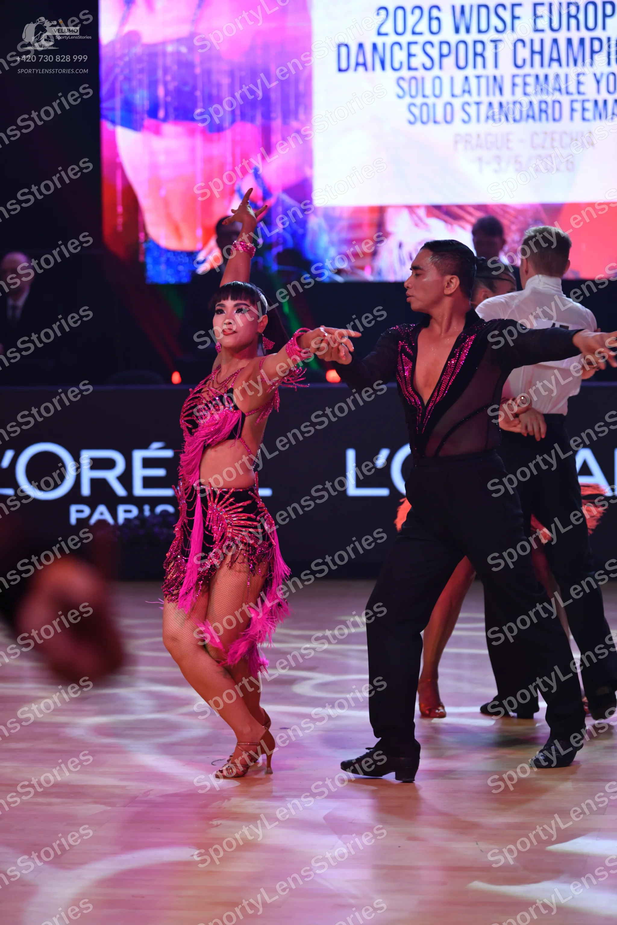 Dancesport competitor: Female dancer: bright pink Latin dress with sequins and fringe