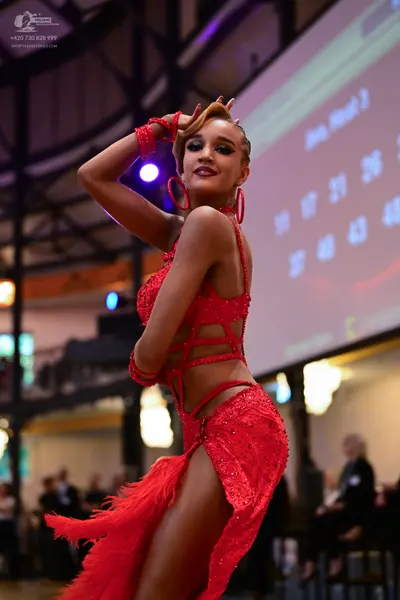 Dancesport competitor: Female dancer: red Latin dress with sequins, cutouts, and fringe