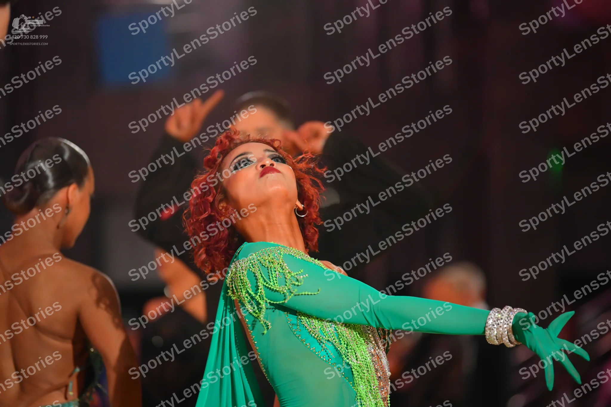 Dancesport competitor: Female dancer: teal long-sleeved latin dress with sparkly beadwork and a sequine