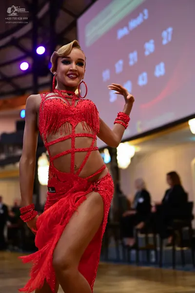 Dancesport competitor: Female dancer: red latin dress with sequins and fringe, featuring cutouts, match