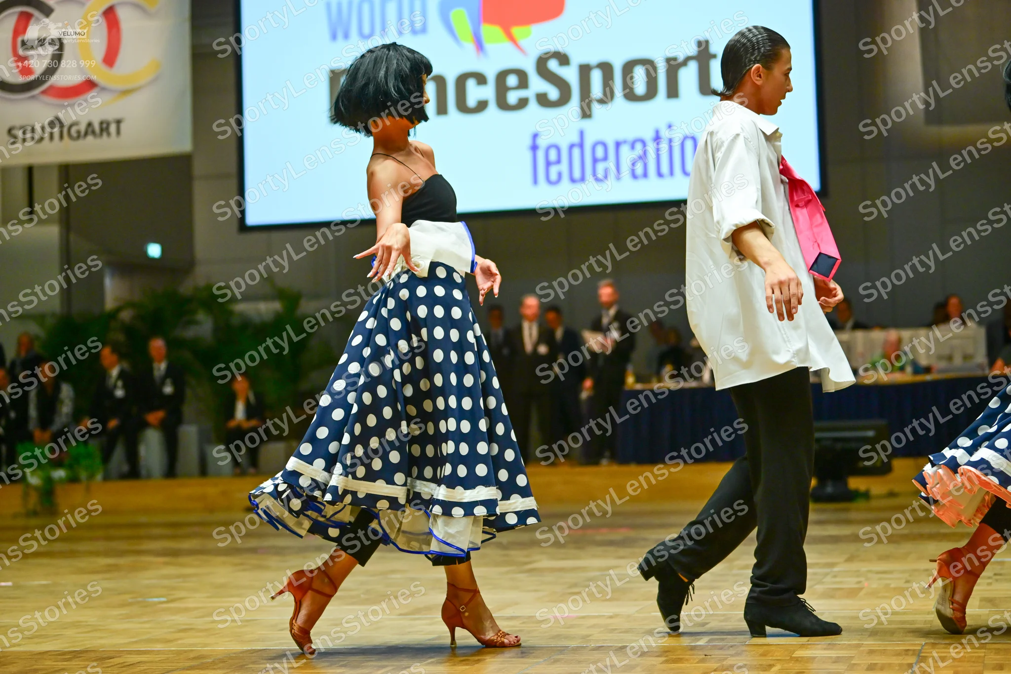 Dancesport competitor: Female dancer: navy blue skirt with large white polka dots, black strapless bodi